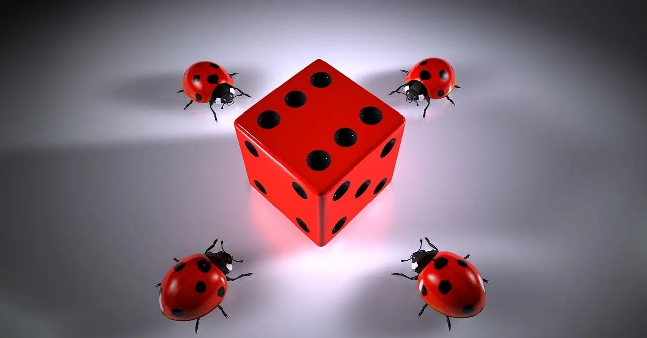 Dado vermelho cercado por quatro joaninhas