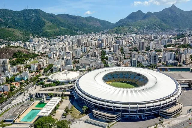 Vista aérea do estádio do Maracanã com a cidade do Rio de Janeiro e montanhas ao fundo