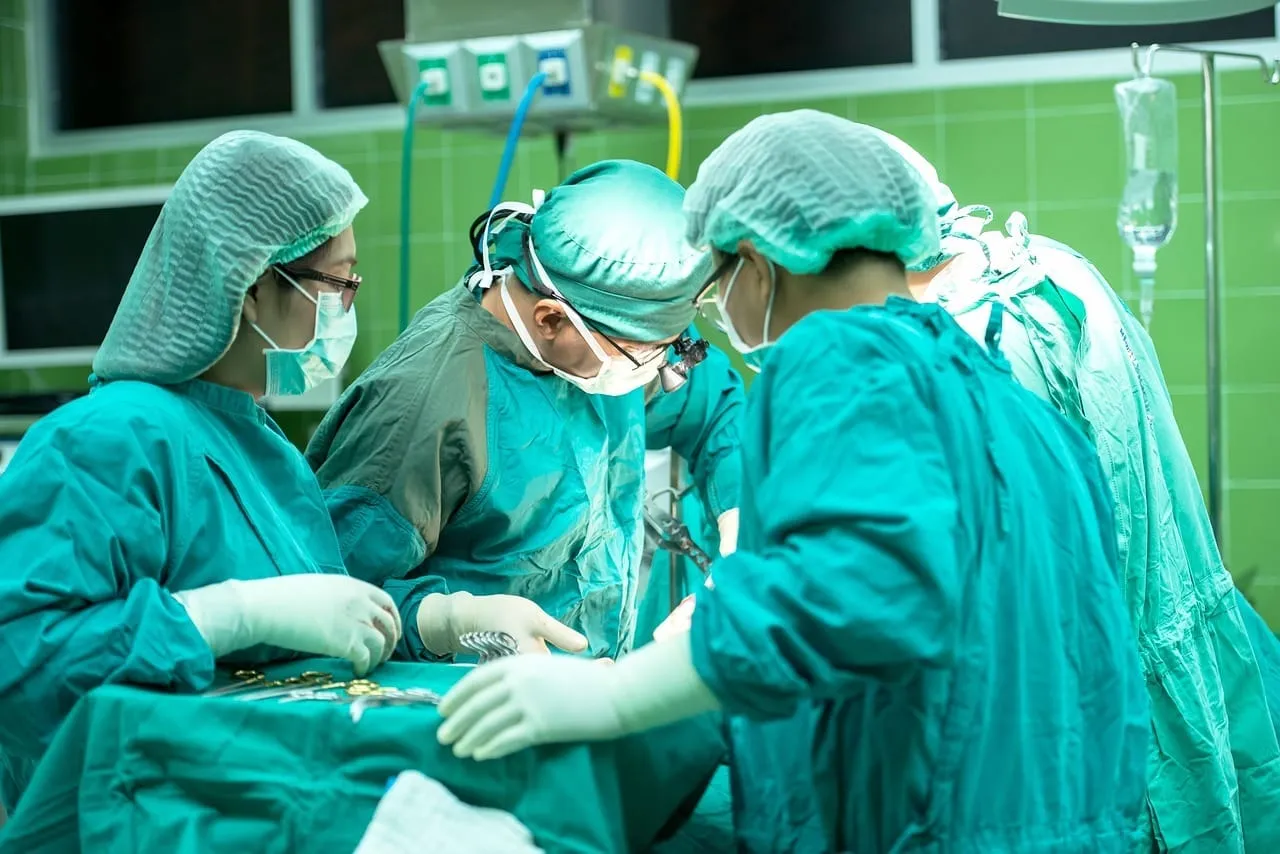 Equipe médica com roupas verdes realizando uma cirurgia