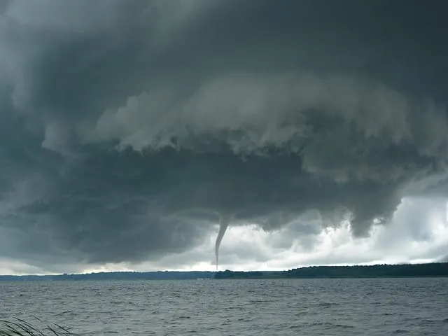 Tornado se formando sob nuvens escuras sobre a água