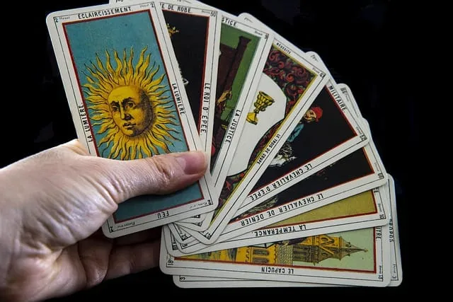 Mão segurando cartas de tarô abertas em leque